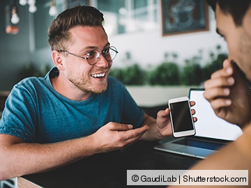 Studierender mit einem Smartphone in der Hand Studierender mit einem Smartphone in der Hand