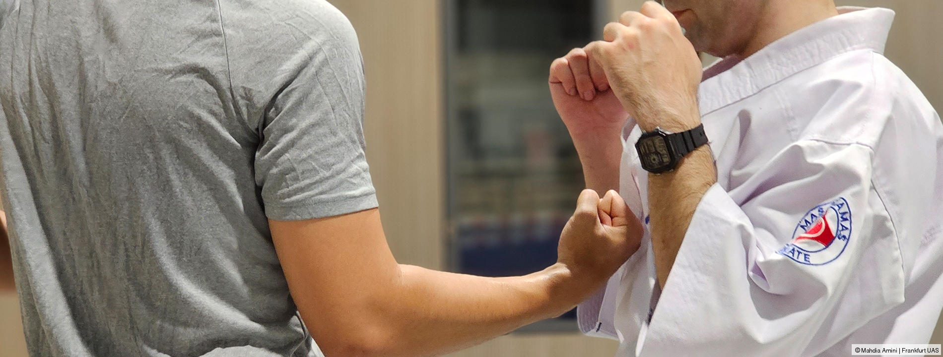Karate Zwei Menschen, der eine hält seine Fäuste hoch und der andere setzt zum Schlag an; Link zum Angebot Karate