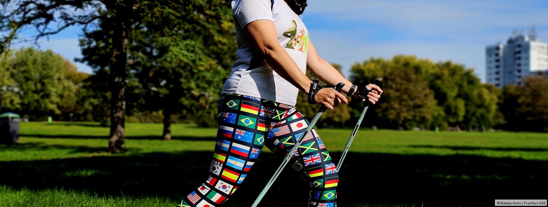Eine Frau bei Sonnenschein im Park mit Nordic Walking Stöcken; Link zum Angebot