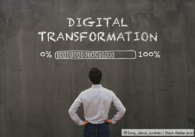 Mann schaut auf Tafel mit Grafik zum Fortschritt der Digitalen Transformation