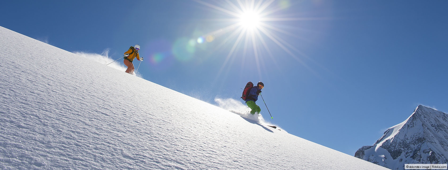 Zwei Skifahrer fahren einen Berg hinunter